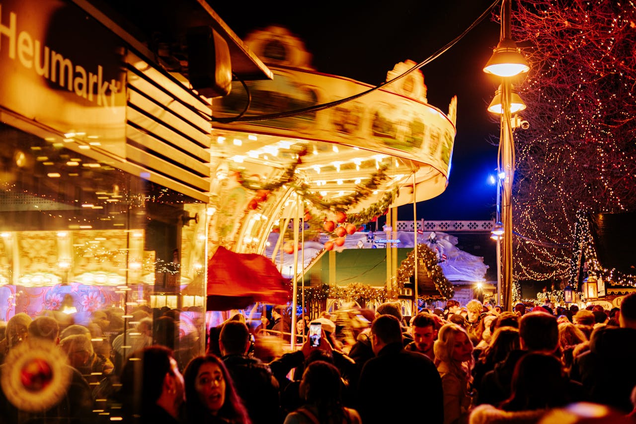 gallery-05 A lively scene at Cologne's Christmas market with a carousel ride and festive lights, captivating crowds in winter.
