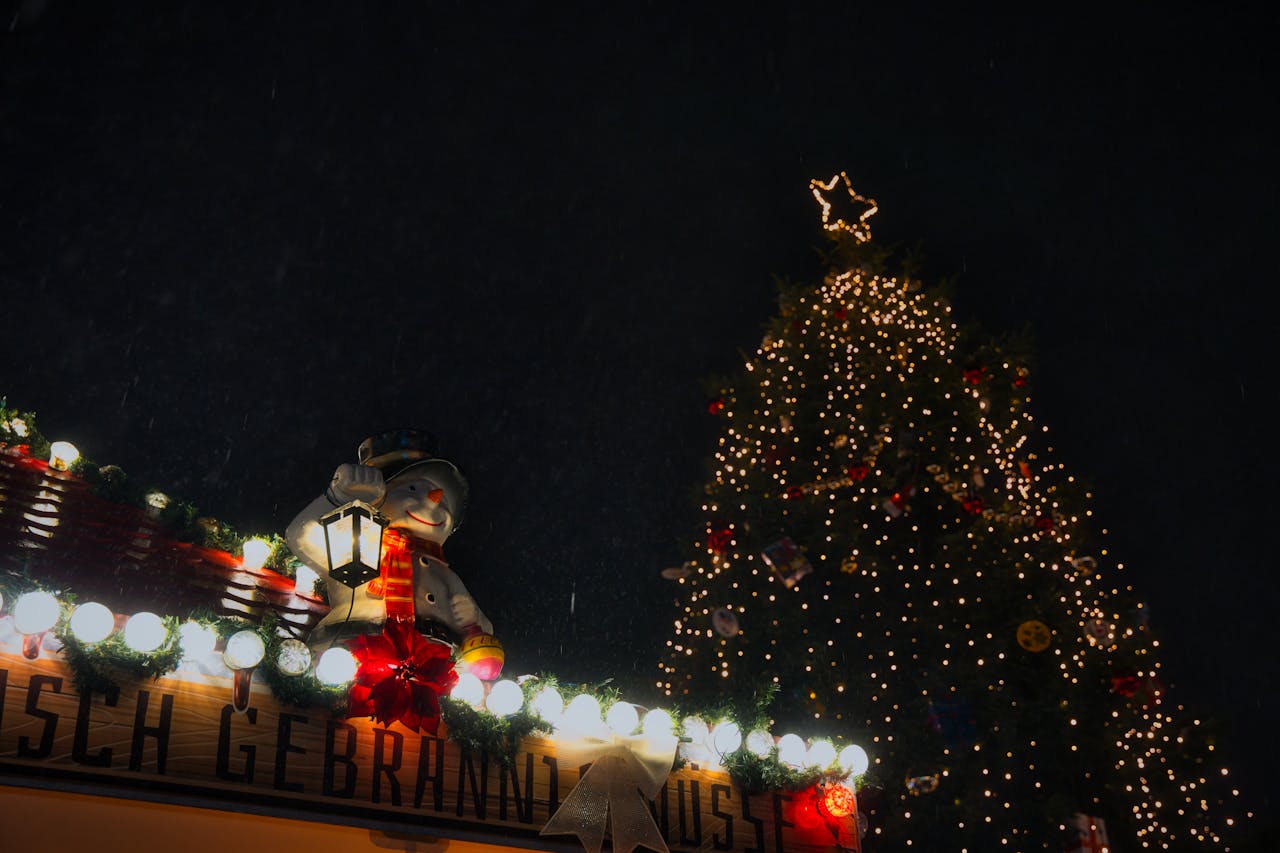 services-02 Snowy Christmas market in Oranienburg with lights and a festive snowman decoration.